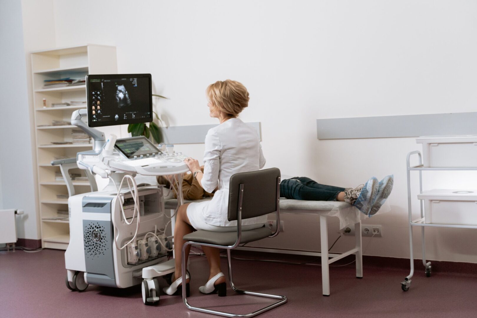 A woman sitting at her desk in front of an ultrasound machine.