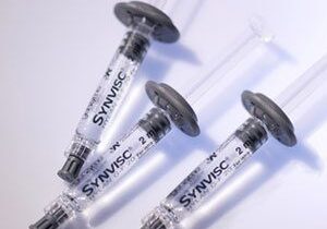 Syringe with a needle and a black cap.